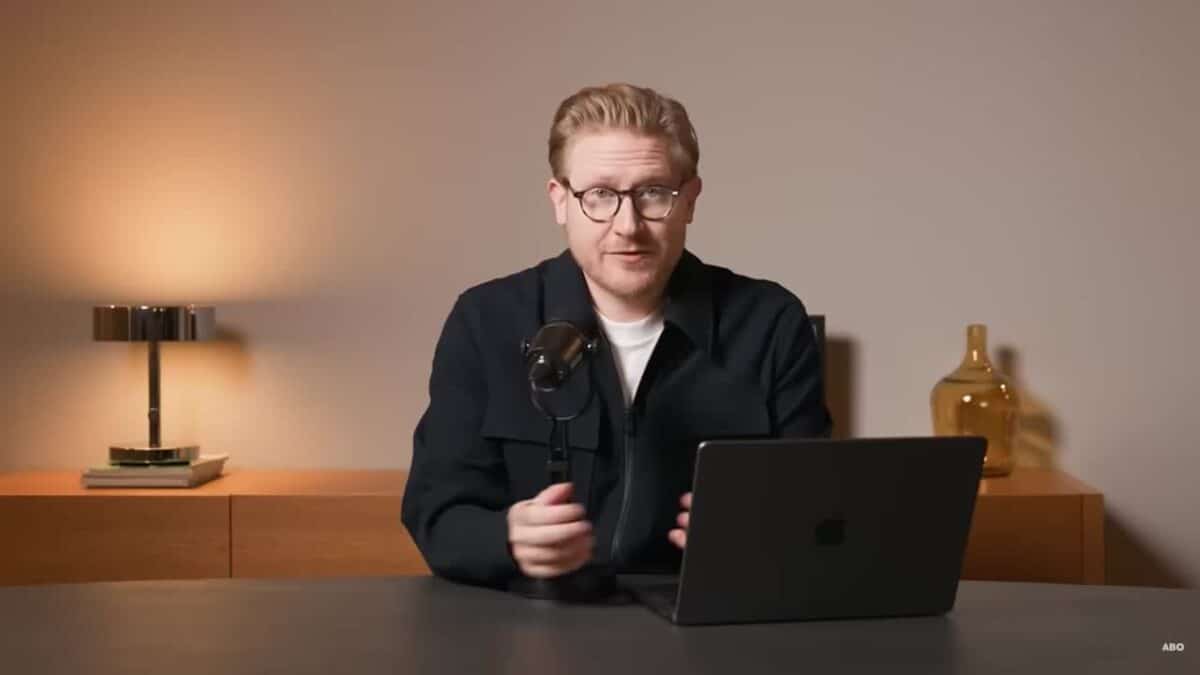 mario lochner vor einer grauen wand nimmt ein neues youtube video auf, mit mikrofon und laptop