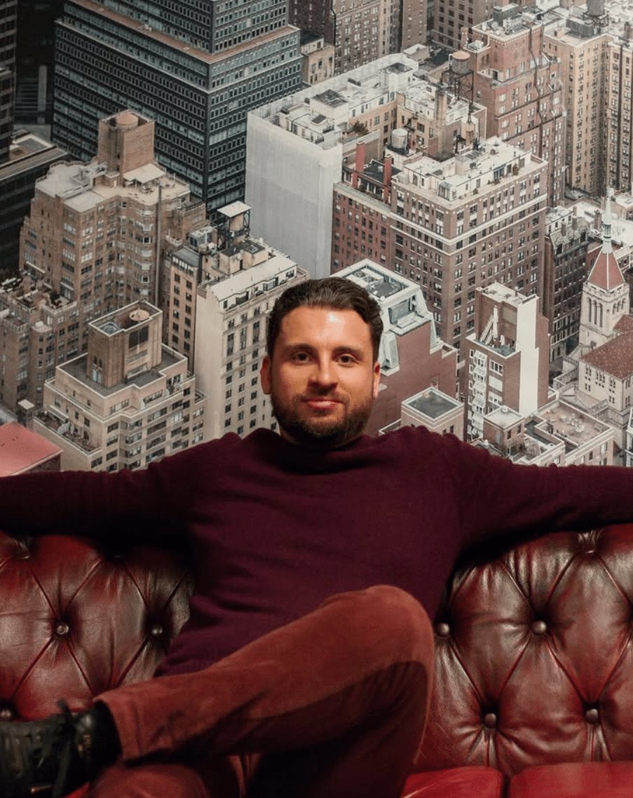 Ist CopyTrade Market seriös? Erfahrungen, Kosten & Funktionen (2026) gründer und geschäftsführer von copytrade market sebastian winzker präsentiert sich auf einer ledercouch vor einem stadtbild